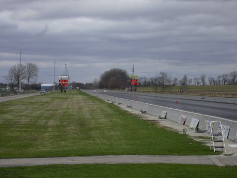 1996 Ford Crown Victoria - A cloudy day at the drag strip, with two cars visible in the distance and a SuperMotors logo at the bottom.