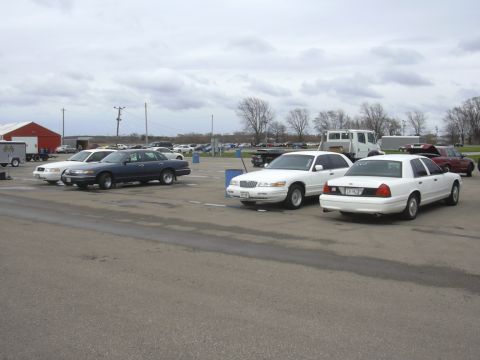 1996 Ford Crown Victoria - A white 1996 Ford Crown Victoria is parked at an outdoor event.