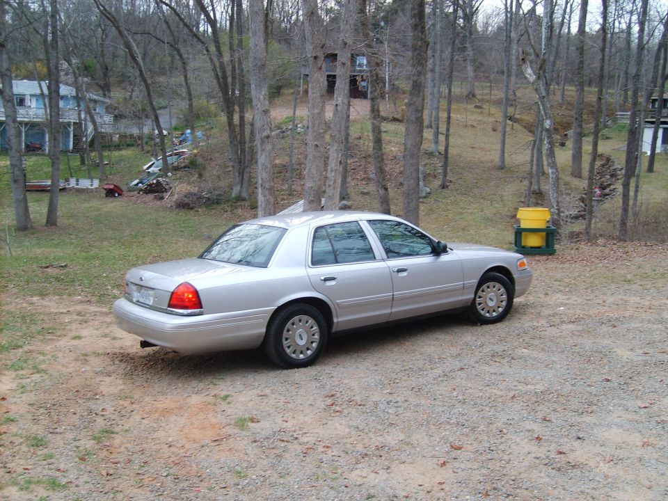 Silver 2004 Ford Crown Victoria parked on a gravel driveway