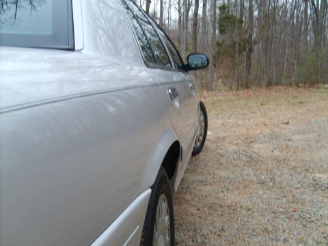 2004 Ford Crown Victoria - The rear quarter panel and door of a silver sedan are visible, parked outdoors.