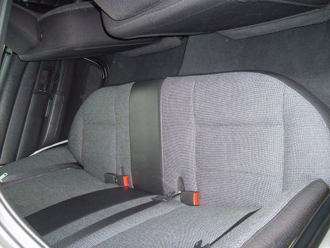 2004 Ford Crown Victoria - The interior of a 2004 Ford Crown Victoria features gray fabric rear seats with black trim and visible seatbelts.