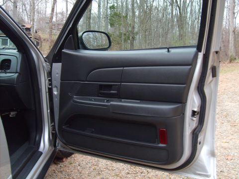 2004 Ford Crown Victoria - Interior view of the driver's side door panel and part of the dashboard in a 2004 Ford Crown Victoria.