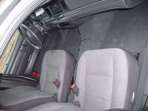 2004 Ford Crown Victoria - The interior of a car is shown, cloth seats and the dashboard area.