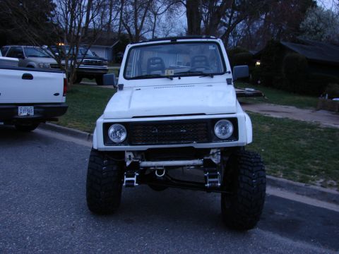1990 Suzuki Samurai - Front view of a modified 1990 Suzuki Samurai with a lifted suspension and custom grille.