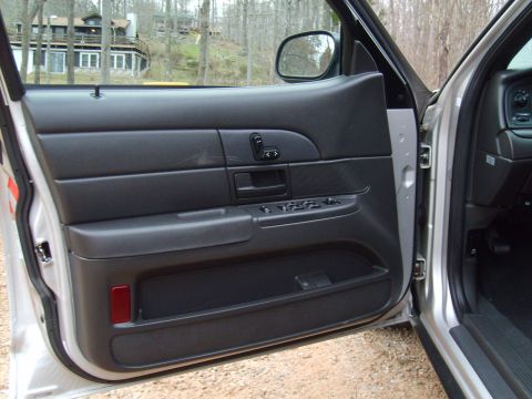 2004 Ford Crown Victoria - The interior door panel of a 2004 Ford Crown Victoria is shown, with the driver's side door open.