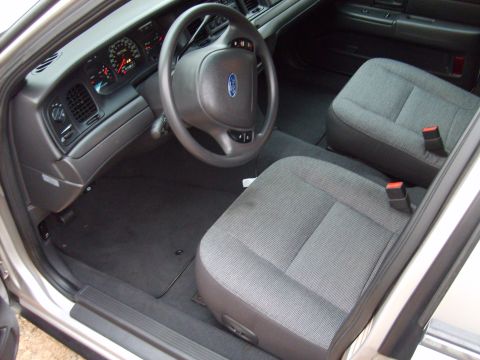2004 Ford Crown Victoria - The interior of a 2004 Ford Crown Victoria, cloth seats and a standard dashboard layout.