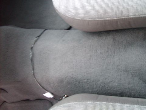 2004 Ford Crown Victoria - Interior view of a car's floor, showing carpet and a visible wire.