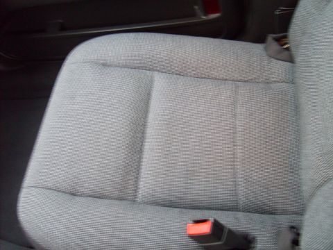 2004 Ford Crown Victoria - Close-up of a car's fabric seat and seatbelt buckle.