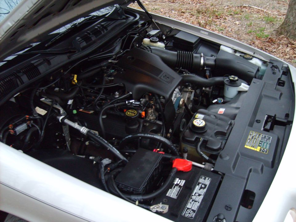Clean stock engine bay of a silver Ford Crown Victoria showing the 4.6L V8