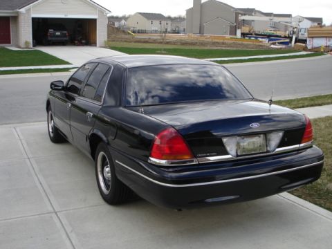 2001 Ford Crown Victoria - Black 2001 Ford Crown Victoria sedan parked in front of a suburban garage.