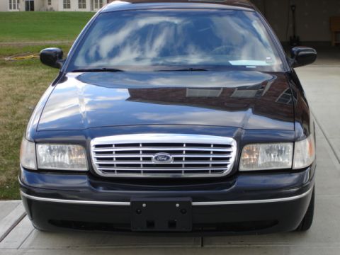2001 Ford Crown Victoria - The front grille and headlights of a black Ford Crown Victoria are visible.