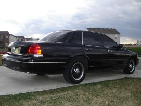 2001 Ford Crown Victoria - Rear 3/4 view of a black 2001 Ford Crown Victoria parked on a driveway.