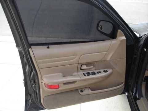 2001 Ford Crown Victoria - The interior door panel of a 2001 Ford Crown Victoria features tan upholstery and power window controls.