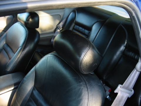 1995 Ford Thunderbird - Interior view of black leather rear car seats, showing the stitching and headrests.