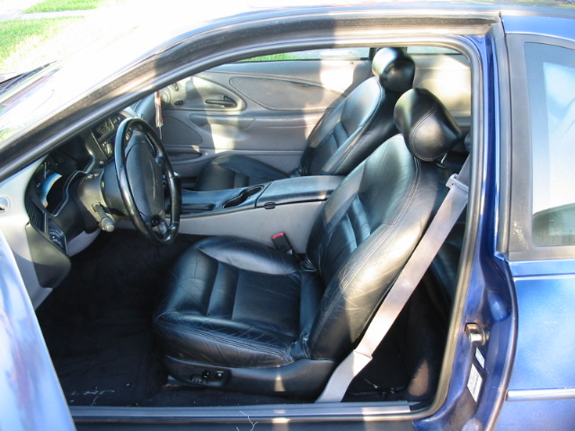 Interior of blue car with black leather seats and dashboard