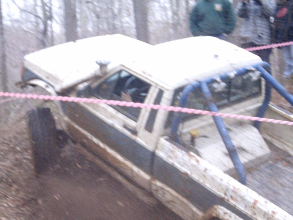 1979 Jeep J-10 pickup truck with blue roll cage, off-roading