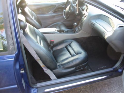 1995 Ford Thunderbird - Interior view of a blue car, focusing on the front seats and dashboard area.