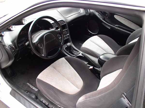 Interior of a 1996 Ford Probe GT showing the driver's seat, dashboard, and center console