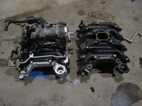 1992 Ford Crown Victoria - Engine and intake manifold components are laid out on a concrete surface, suggesting a repair or rebuild process.