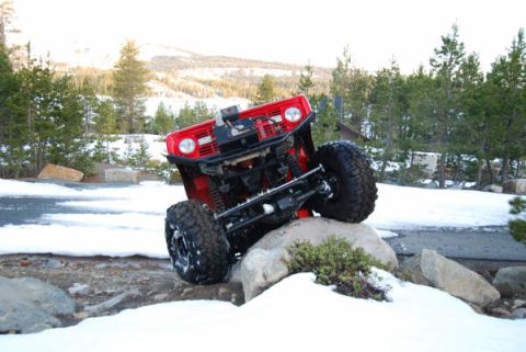 1989 Ford Bronco - This red 1989 Ford Bronco navigates a challenging rocky terrain covered in snow.