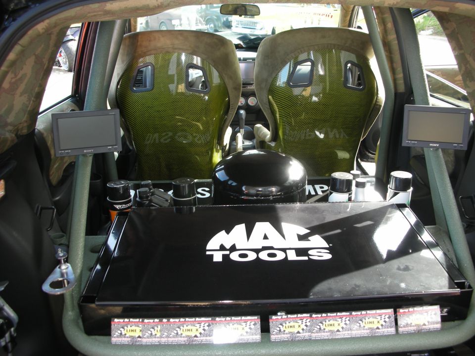 Custom hatchback rear cargo area with carbon-look seats, screens and Mac Tools tray