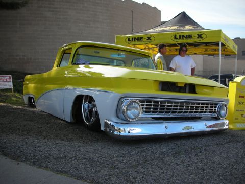 1998 Ford Crown Victoria - A custom pickup truck with a two-tone paint job and chrome accents sits low to the ground.