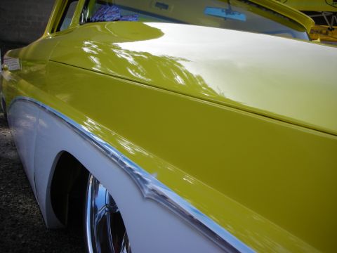 1998 Ford Crown Victoria - Close-up view of the fender and hood of a yellow and white two-tone pickup truck, chrome trim and a lowered stance.