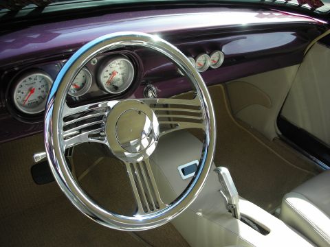 1998 Ford Crown Victoria - The interior of a custom car features a purple dashboard and a chrome steering wheel with multiple gauges.