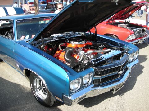 1998 Ford Crown Victoria - Blue 1970 Chevelle SS at a car show, engine exposed. Another car is visible behind.