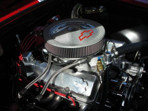 1998 Ford Crown Victoria - Close-up view of a Chevrolet engine bay, a chrome air cleaner with the iconic bowtie logo and red spark plug wires.