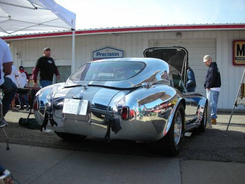 1998 Ford Crown Victoria - A highly polished Shelby Cobra replica is displayed outdoors with its trunk open, reflecting the surroundings.