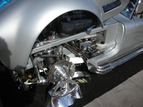 1998 Ford Crown Victoria - Close-up of a silver car's engine bay, the 'COBRA 427' engine and polished front suspension components.