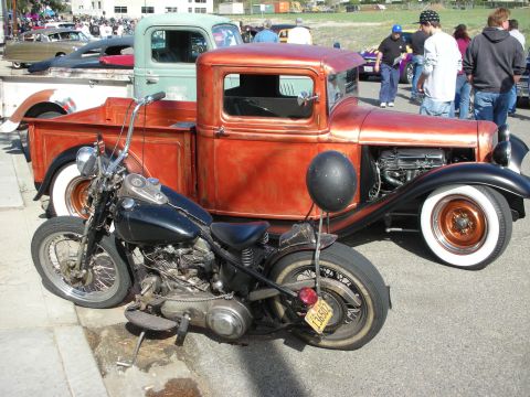1998 Ford Crown Victoria - Motorcycle and hot rod pickup truck at an outdoor car show.