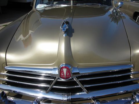 1998 Ford Crown Victoria - Close-up of a gold Hudson's front grille and hood ornament, likely from the early 1950s.