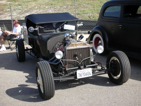 1998 Ford Crown Victoria - A custom hot rod is displayed next to another vehicle at an outdoor event.