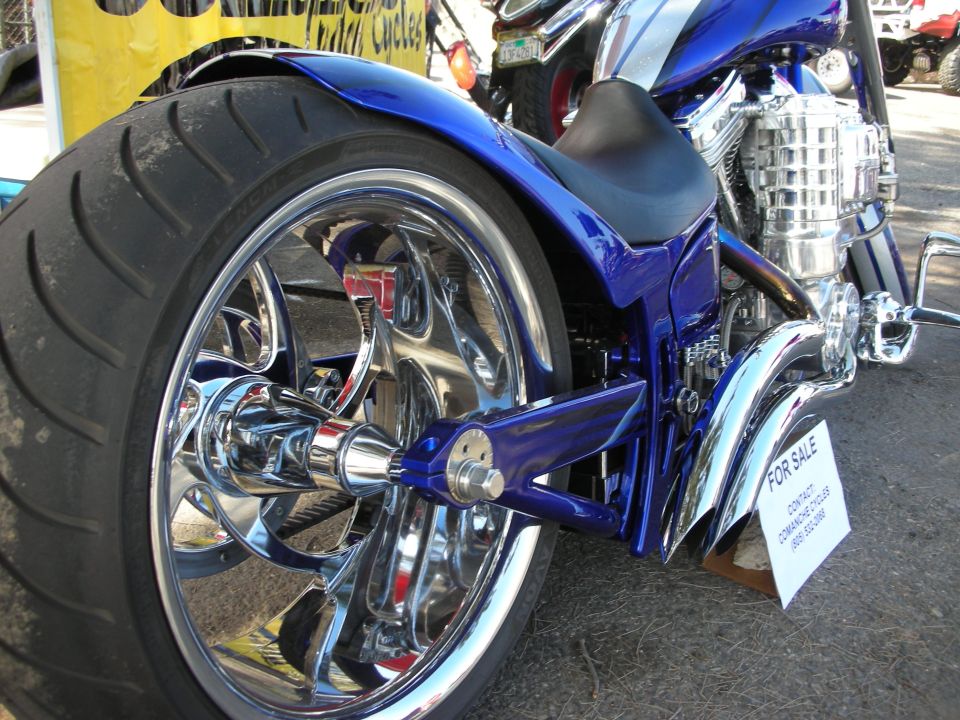 Rear of blue custom chopper with chrome billet wheel and For Sale sign