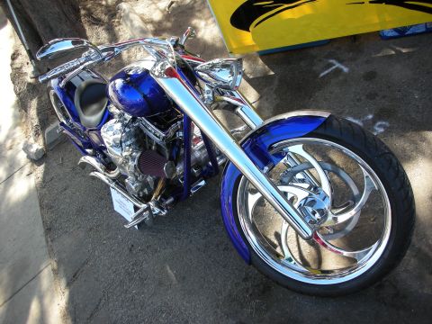 1998 Ford Crown Victoria - Custom chopper motorcycle with a bright blue metallic paint job and extensive chrome detailing.
