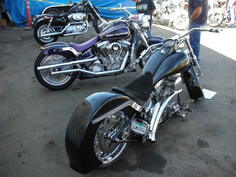 1998 Ford Crown Victoria - Multiple custom motorcycles are displayed outdoors, with people in the background.