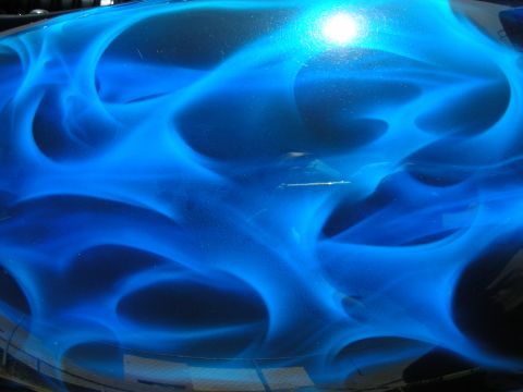 1998 Ford Crown Victoria - A car hood displays custom blue flame airbrushing with visible scratches.