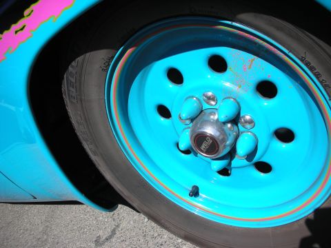 1998 Ford Crown Victoria - A bright blue Weld Racing wheel with chrome lug nuts is shown, with pink and yellow graphics on the fender.