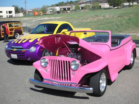 1998 Ford Crown Victoria - Three custom vehicles, including a pink jeep and a yellow Chevrolet SSR, are parked outdoors.