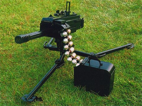 1998 Ford Crown Victoria - A heavy machine gun is mounted on a tripod with a belt of ammunition ready to be fed into the weapon.