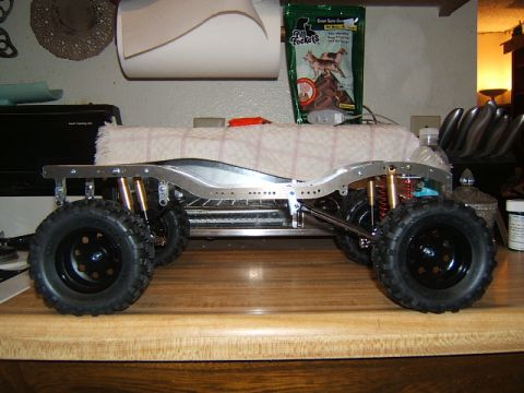 1988 Ford Bronco - Side view of an RC car chassis with prominent suspension and large off-road tires.