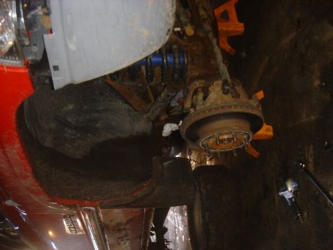 1979 Ford F-250 - Undercarriage view of a truck's suspension and brake components, possibly during repair.