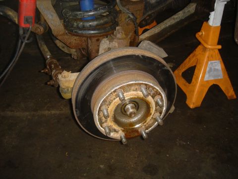 1979 Ford F-250 - The front wheel hub and brake assembly of a truck are shown, supported by a jack stand.