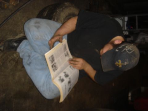 1979 Ford F-250 - A person is seated on the floor, engrossed in reading a technical manual.