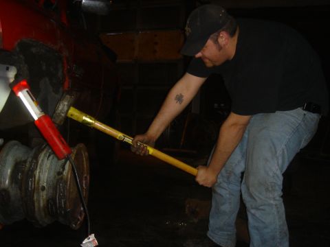 1979 Ford F-250 - A person uses a sledgehammer on a vehicle component, possibly during repair or modification.