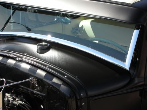 1998 Ford Crown Victoria - A detail shot of a classic car's front end, focusing on the hood and windshield area.