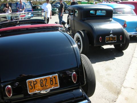 1998 Ford Crown Victoria - Two hot rod cars, a convertible and a coupe, are parked side-by-side at an outdoor event.