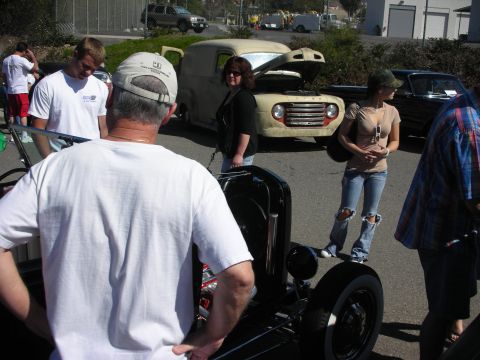 1998 Ford Crown Victoria - A group of people admire a vintage panel van and a hot rod at an outdoor car show.